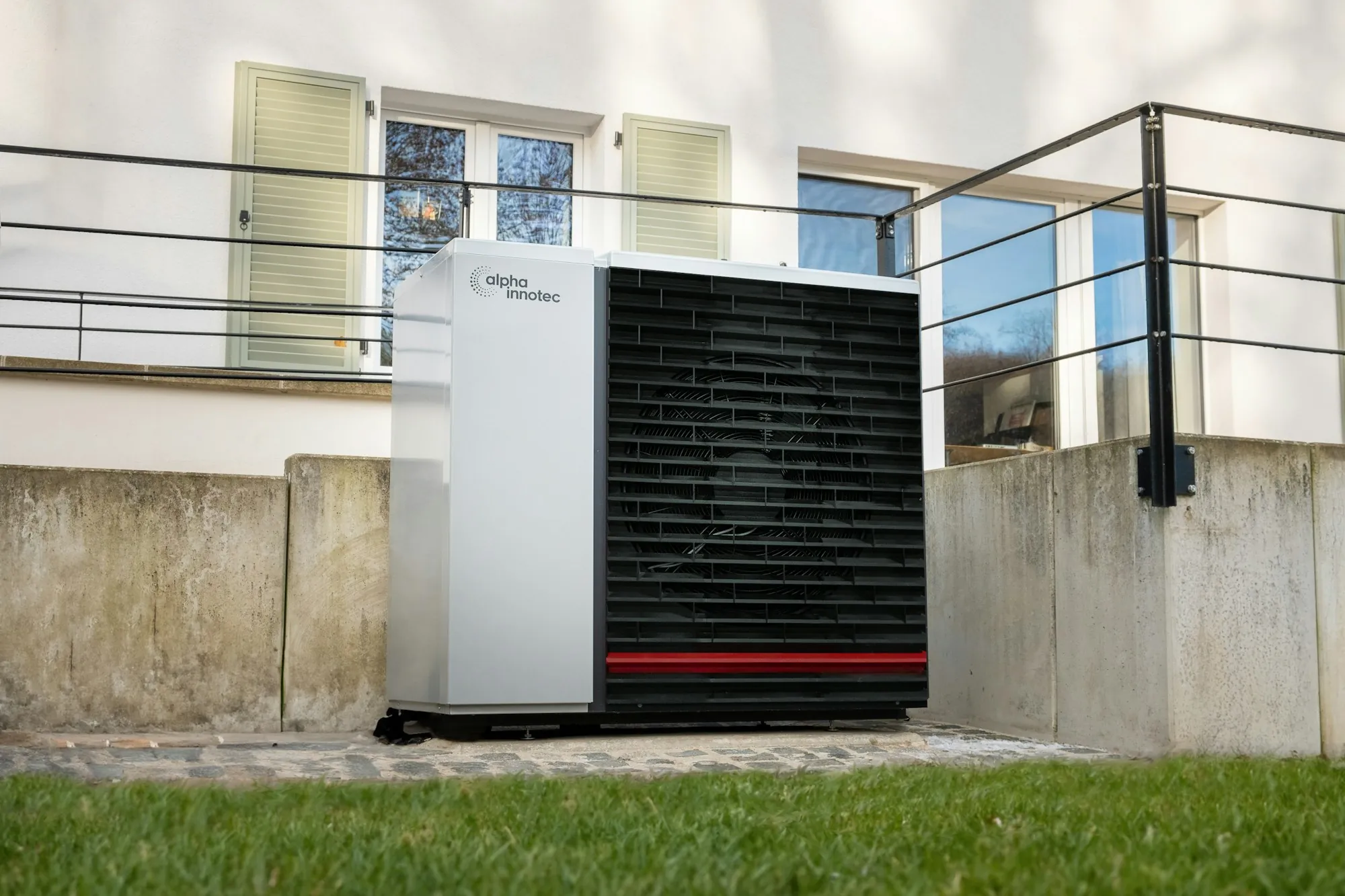 Heat pump unit installed on a lawn beside a house
